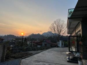 a sunset over a town with a house and a building at Minh_Thắm in Bắc Hà