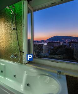 a bath tub in front of a window with a view at A Heritage Split in Split