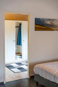 a bedroom with a bed and a mirror at De Vrijheid-Melkstal in De Cocksdorp