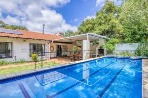 a swimming pool in front of a house at Chic Midtown Studio-1 Bed-solar-pool-fibre-samrand in Centurion