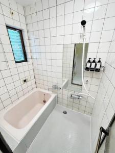 a white bathroom with a tub and a mirror at 【2024/2月OPEN! 一軒家貸切】東京ディズニーリゾートまで車5分、徒歩20分 in Urayasu +12 photos