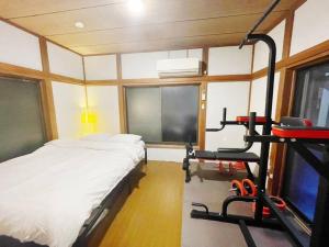 a bedroom with a bed and a treadmill at 【2024/2月OPEN! 一軒家貸切】東京ディズニーリゾートまで車5分、徒歩20分 in Tokyo