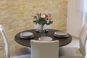 stół jadalny z wazonem kwiatów w obiekcie Luxury Apartment with Sauna w Koszycach