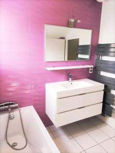 uma casa de banho com um lavatório branco e um espelho. em Maison avec jardin au pied du Viaduc de Millau em Creissels