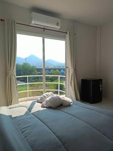 a bedroom with a large bed with a large window at Wave House Studio Huahin in Hua Hin