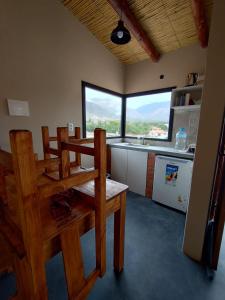 a kitchen with a wooden table and chairs in a room at CABAÑAS RIVIERA in Huacalera