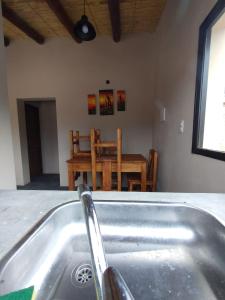 a kitchen with a sink and a table with a chair at CABAÑAS RIVIERA in Huacalera +5 photos