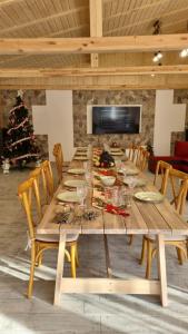 a long wooden table with chairs and a christmas tree at Muntele cu dor in Buzău