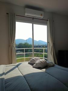 a bed in a bedroom with a large window at Wave House Studio Huahin in Hua Hin