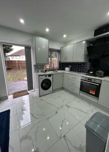 a kitchen with white cabinets and a dishwasher at Peaceful Studio - Near NEC, BHX Airport. in Birmingham