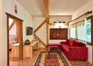a living room with a red couch and a table at Pyramid Boutique Hotel in Kayakoy