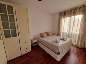 1 dormitorio con cama y ventana grande en El Atico de Sabadell muy cerca del centro, en Sabadell