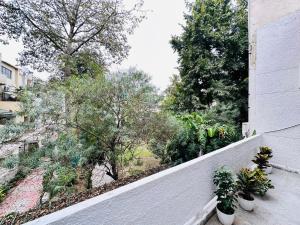 uma varanda com plantas e árvores num edifício em Grove Residency Hauz Khas New Delhi Couple Friendly em Nova Deli