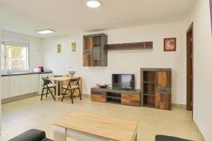 ein Wohnzimmer mit einem TV und einem Tisch in der Unterkunft Villa verde in Córdoba