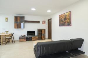 ein Wohnzimmer mit einem Sofa und einem Tisch in der Unterkunft Villa verde in Córdoba
