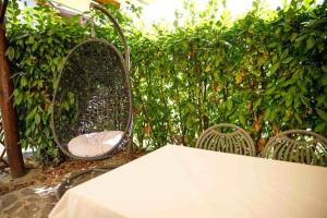 stół, dwa krzesła i żywopłot w obiekcie Agriturismo Podere Bucine Basso w mieście Lari