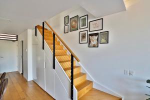 una escalera en una casa con fotos en la pared en Lumière Urban Hideaway-Split Level ·Views ·Parking en Sídney