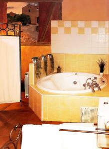 y baño con bañera y pared de azulejos. en Alojamientos Rurales EL VALLEJO, en Guadalajara