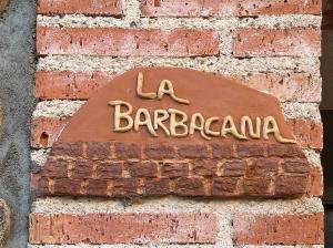 um sinal no lado de uma parede de tijolos em Alojamientos Rurales EL VALLEJO em Guadalajara