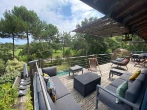 une terrasse avec des canapés, une table et des chaises dans l'établissement Villa 24 Moliets, à Moliets-et-Maa