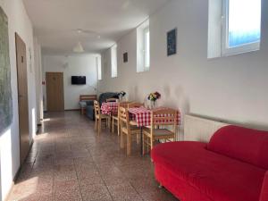 Turistická ubytovňa Jurčišin في سنينا: غرفة معيشة مع طاولة وأريكة حمراء