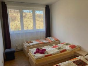 three beds in a room with a window at Turistická ubytovňa Jurčišin in Snina