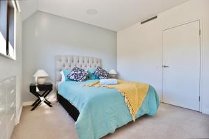 1 dormitorio con 1 cama con sábanas y almohadas azules en Lumière Urban Hideaway-Split Level ·Views ·Parking en Sídney