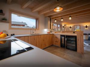 a kitchen with wooden cabinets and a large window at Chalet Evonyx - OVO Network in Samoëns