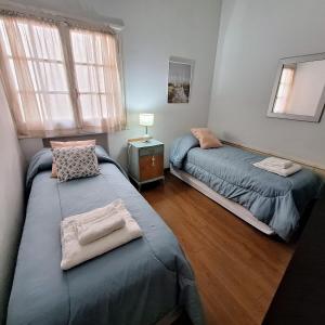a bedroom with two beds and a window at Posta Belgrano in Mendoza