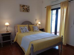 a bedroom with a bed with yellow sheets and a window at Villa Lucia, Olhos D'Agua, Albufeira in Albufeira +32 photos