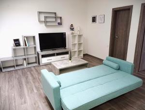 sala de estar con sofá azul y TV en Apartmán Marty, en Nové Zámky