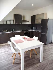 a kitchen with a white table and white chairs at Apartmán Marty in Nové Zámky