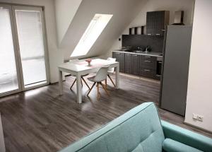 a living room with a white table and a kitchen at Apartmán Marty in Nové Zámky