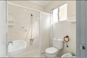 a white bathroom with a toilet and a sink at Casa Mata cerca de Paseo Marítimo Antonio Banderas in Málaga