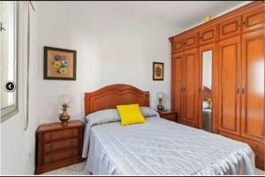 a bedroom with a bed with a yellow pillow on it at Casa Mata cerca de Paseo Marítimo Antonio Banderas in Málaga
