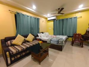 a living room with a couch and a bed at CHARULATA RESIDENCY in Bolpur