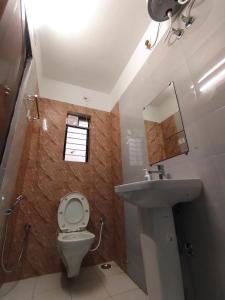 a small bathroom with a toilet and a sink at CHARULATA RESIDENCY in Bolpur