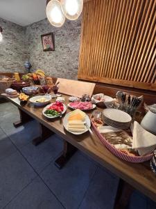 a wooden table with plates of food on it at Haus zum guten Hirten in Steinsfeld