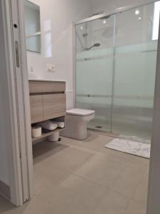 a bathroom with a toilet and a glass shower at La Villa des Fleurs in Hendaye