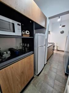 eine Küche mit einem weißen Kühlschrank und einer Mikrowelle in der Unterkunft Posta Belgrano in Mendoza