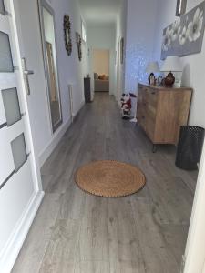 a hallway with a rug on a hard wood floor at La Villa des Fleurs in Hendaye