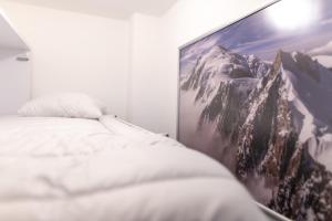 een slaapkamer met een foto van een besneeuwde berg bij New high-end apartment 6P3BR - Haut Combloux in Cordon