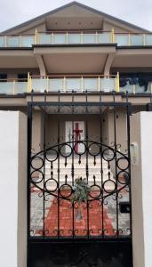 uma varanda com um portão em frente a um edifício em AMLA “ Guesthouse “ em Shkodër