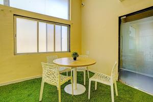 een tafel en stoelen in een kamer met een raam bij Collection O Sunset Residency in Mumbai