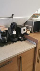 a kitchen counter with a coffee maker and a microwave at Apartament Kalinderu K1 Bușteni in Buşteni