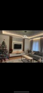 uma sala de estar com uma árvore de Natal e um sofá em AMLA “ Guesthouse “ em Shkodër