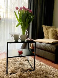 a living room with a glass table with a vase of flowers at Royal Place 2 bedrooms Apartment Wilanów in Warsaw