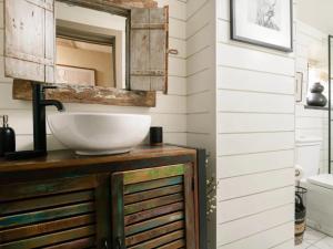 un baño con lavabo y espejo en Howman House, en Cheltenham 14 fotos más