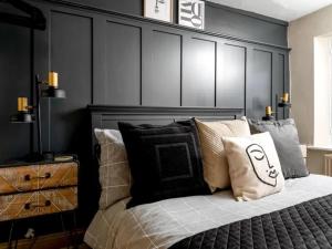 1 dormitorio con cabecero negro y cama con almohadas en Howman House en Cheltenham