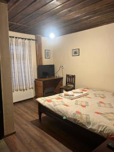 Schlafzimmer mit einem Bett, einem Schreibtisch und einem Computer in der Unterkunft Guest House Popov in Marchevo
